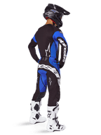 Pantalon Alpinestars Techstar Dreem 2025, pantalon de motocross, noir et bleu, porté par un pilote avec un équipement complet comprenant un maillot assorti, un casque noir et des bottes blanches, arborant un logo blanc imposant à l'arrière et une coupe de course axée sur la performance.