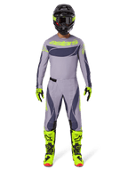 Motocross-Fahrer in kompletter Rennausrüstung, Alpinestars 2025 Techstar Dreem Hose in Grau und Dunkelgrau, passendes Trikot mit fluoreszierend gelbem Branding, schwarzer Helm, fluoreszierend gelbe Stiefel und Handschuhe, abgestimmtes Performance-Outfit für Offroad-Rennen