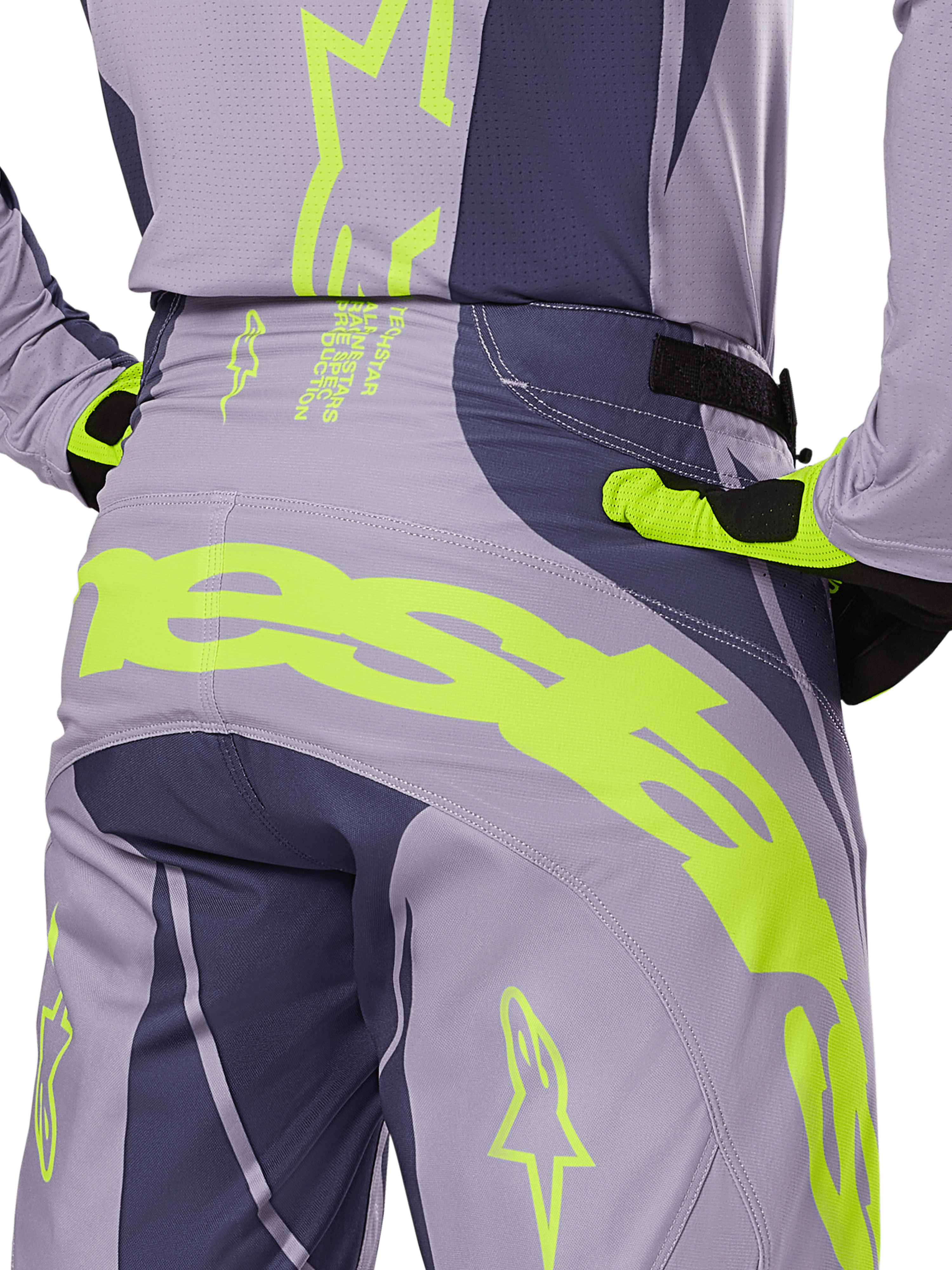Alpinestars 2025 Techstar Dreem Hose, Motocross-Hose, Grau und Dunkelgrau mit leuchtend limonengrünen Akzenten, Rückansicht im Detail mit passendem Trikot und Handschuhen, großes neongelbes Branding am Gesäß, athletische Rennpassform für den Offroad-Sport