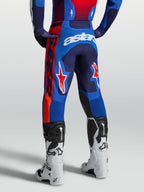 Alpinestars Racer Hunt broek, heren motocrossbroek in blauw en rood, voorgevormde racepasvorm voor professionele off-road prestaties, achterzicht op model.