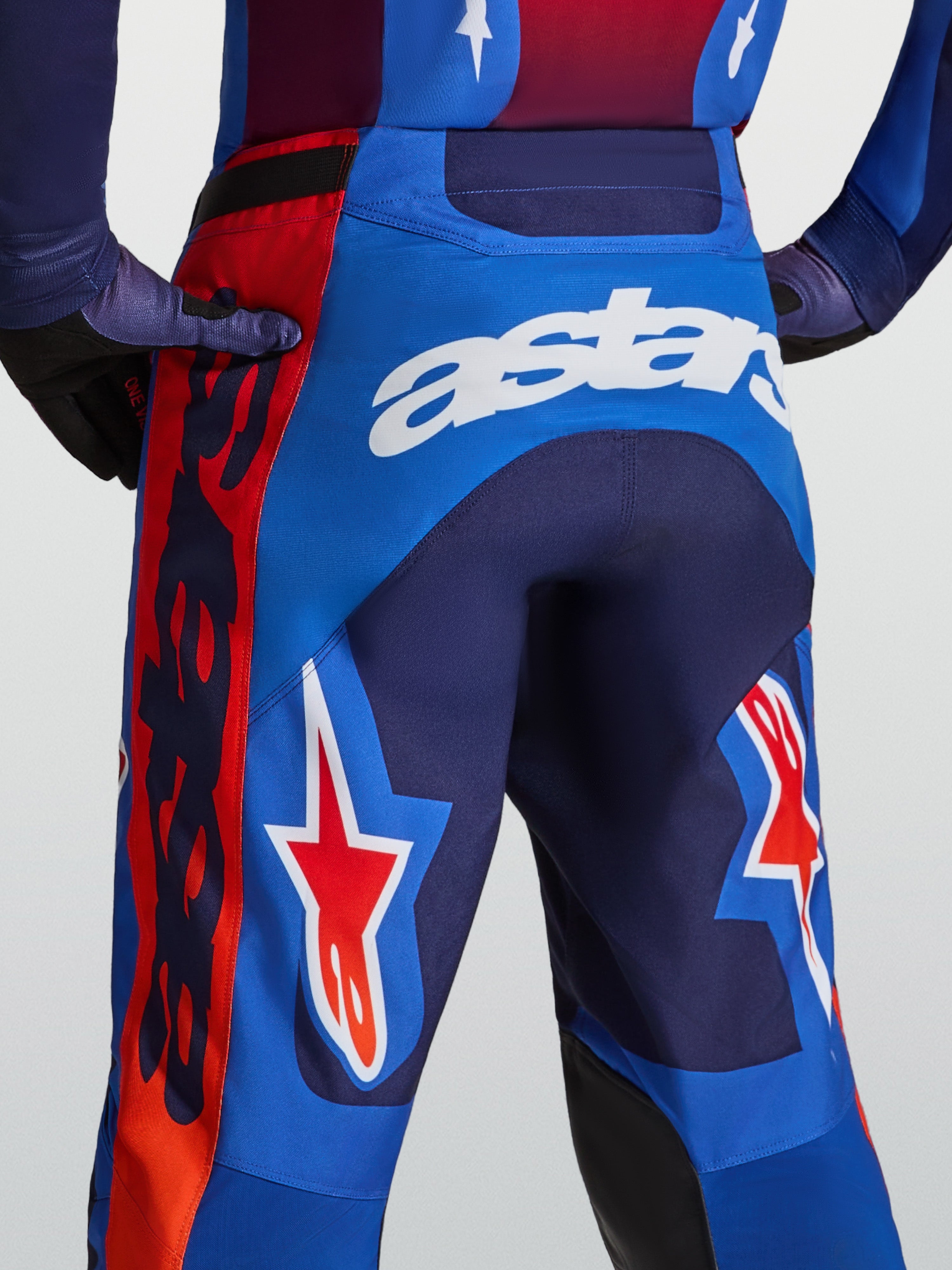 Alpinestars Racer Hunt heren-motorcrossbroek, blauw en rood met witte astars-branding en stergrafieken.