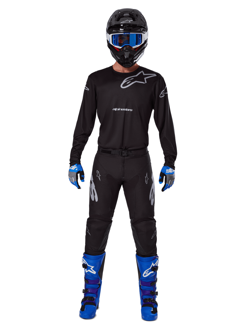 Pantalon Alpinestars 2025 Racer Graphite, pantalon de motocross, noir et gris, porté par un mannequin avec un maillot noir assorti, des bottes bleues et violettes et un masque bleu, tenue de course tout-terrain complète avec logo Alpinestars