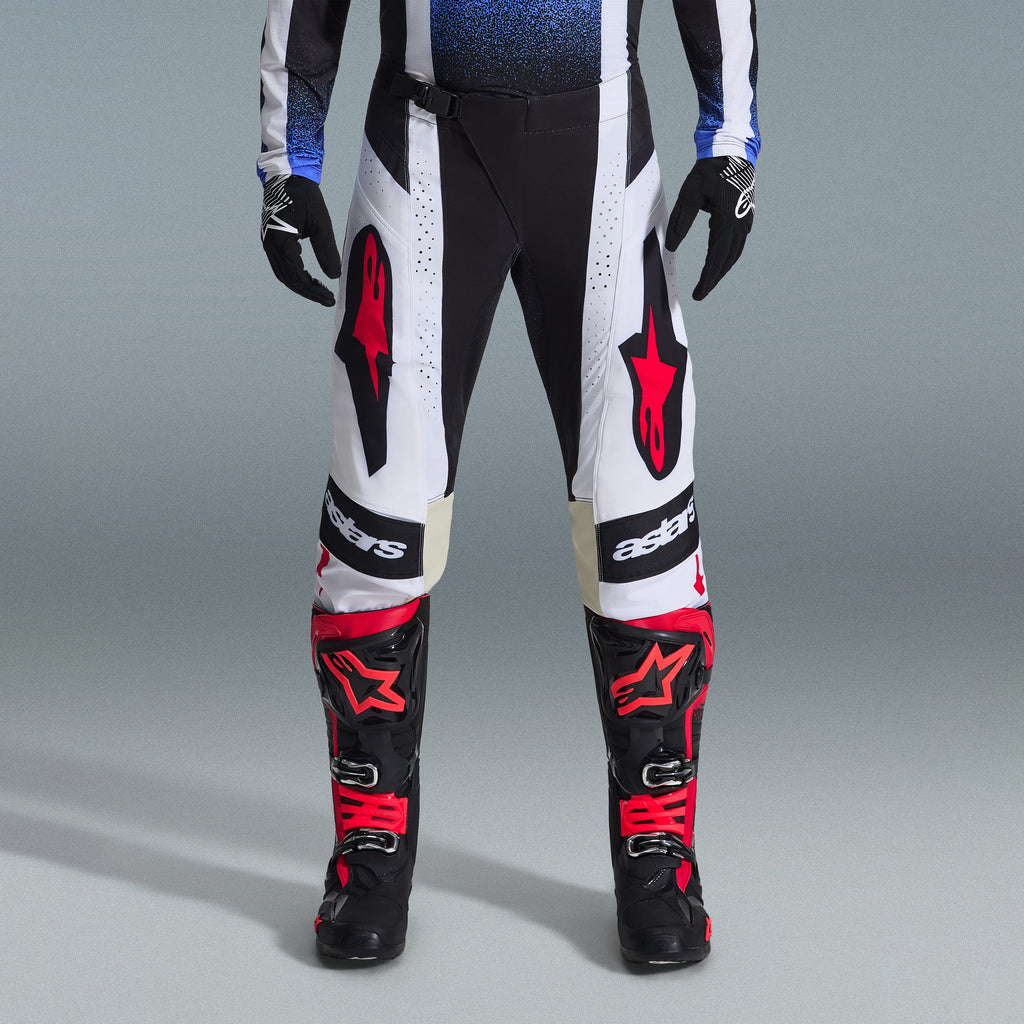 Alpinestars 2026 Techstar Knif Gear Set, Motocross gear, Black and White pants with large Red star logos, worn with black and red racing boots and black gloves, professional athletic fit for off-road performance