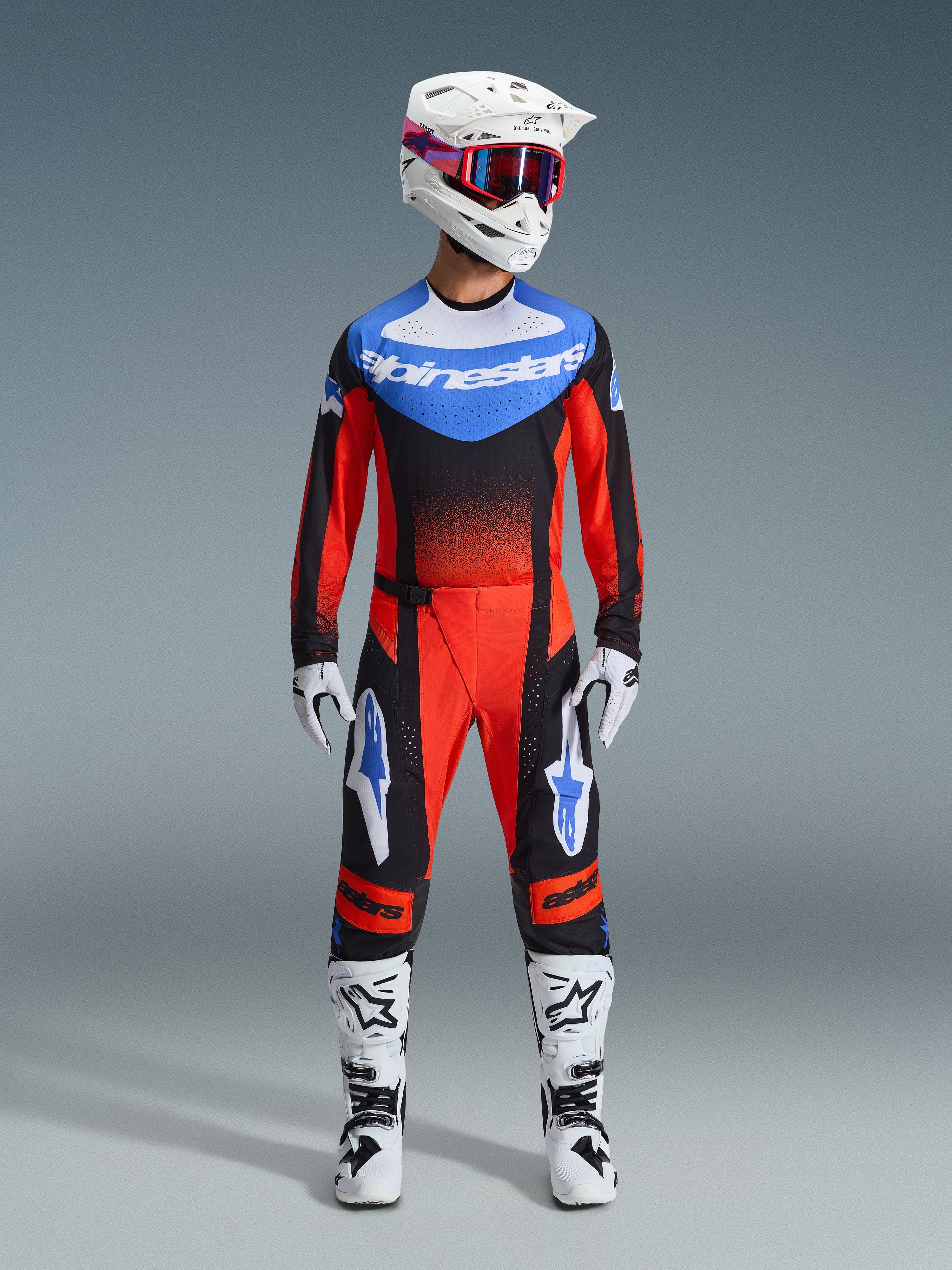 Alpinestars 2026 Techstar Knif Gear Set, équipement de course de motocross, rouge et noir avec accents bleus, tenue de motocross complète incluant maillot, pantalon, casque blanc avec graphismes roses et bleus, gants blancs et bottes blanches, équipement de compétition tout-terrain professionnel