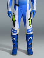 Alpinestars 2026 Techstar Knif Pants, Motocross Pants, Ucla Blue, Black, and Yellow Fluo, worn with matching blue gloves and boots, featuring white panels and vibrant yellow fluo logos, ergonomic racing fit for off-road performance