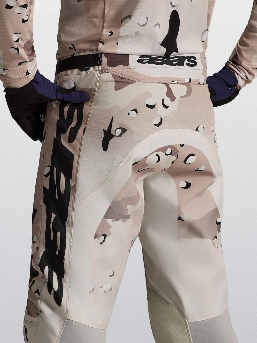 Alpinestars Racer Lone broek, heren-motorcrossbroek in woestijncamouflage en zwart, achteraanzicht op model met racepasvorm.