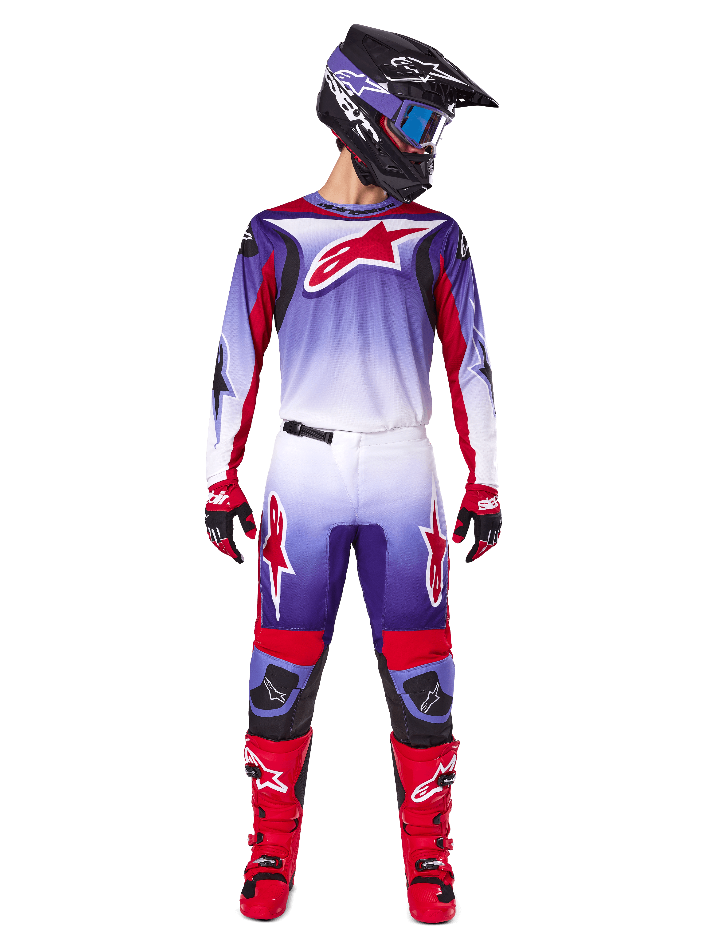 Alpinestars 2025 Fluid Wurx Gear Set, motorcrossrijder in paars, wit en felrood shirt en broek, zwarte helm met blauwe bril, rode motorcrosslaarzen en bijpassende handschoenen, sportief ontwerp voor off-road prestaties