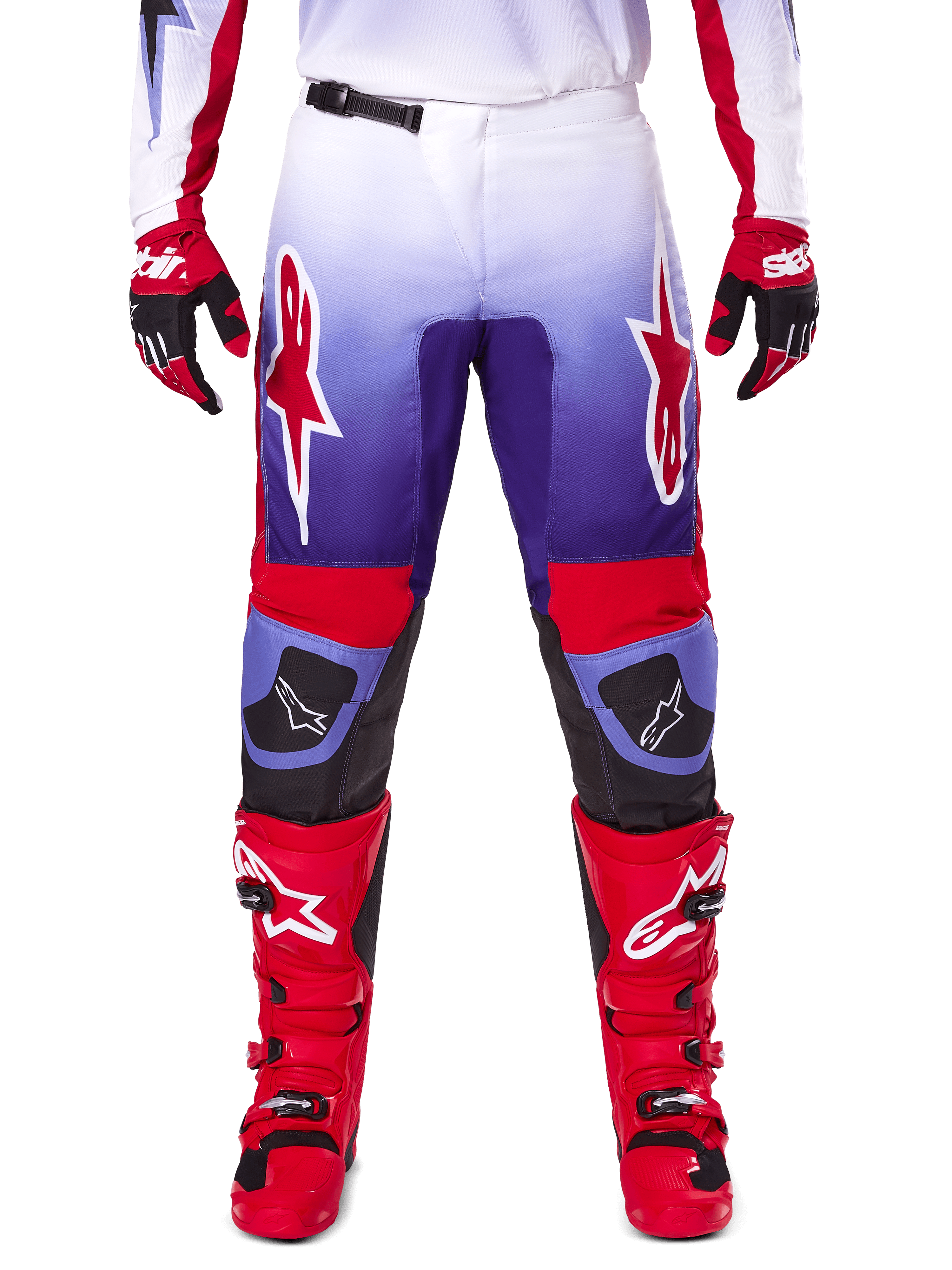 Alpinestars 2025 Fluid Wurx broek, motorcrossbroek, paars en felrood, gedragen met bijpassende rode laarzen en handschoenen, voorzien van witte logo's op de dijen en zwarte knieversterkingen, performance-uitrusting voor off-road rijden
