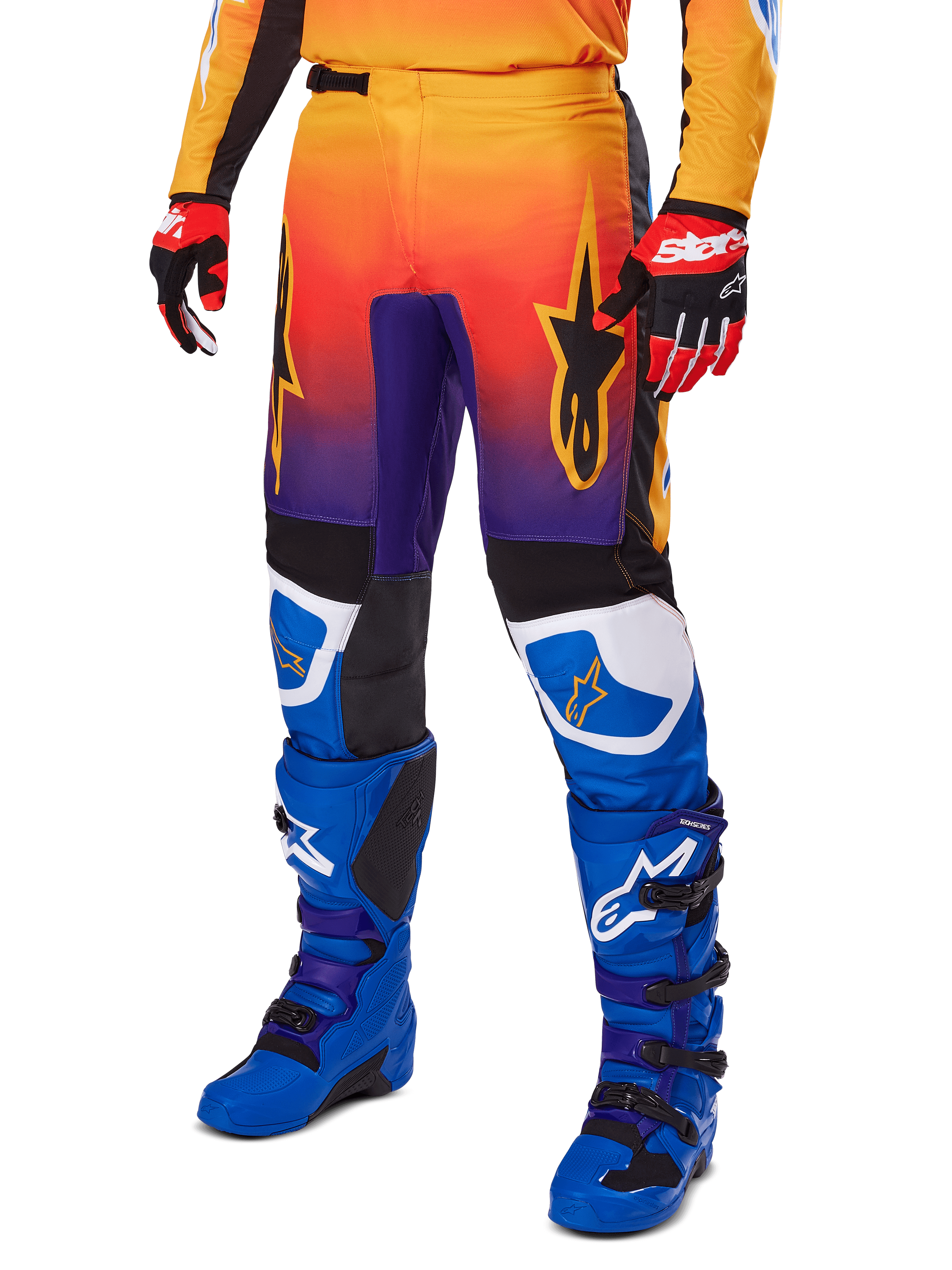 Alpinestars 2025 Fluid Wurx Hose, Motocross-Hose, mehrfarbiger Farbverlauf in Orange, Rot und Lila mit schwarzen und blauen Einsätzen, getragen mit blauen Stiefeln und roten Handschuhen, mit Stern-Logo-Grafiken und weißen Knie-Akzenten, strapazierfähige Performance-Ausrüstung für Offroad-Rennsport