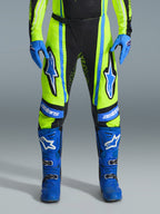 Alpinestars 2026 Techstar Nomur Pants, Motocross Pants, Yellow Fluo and Dark Navy with Blue accents, worn with matching blue gloves and boots, featuring bold Astars logos on the thighs and a performance-engineered design for off-road racing.