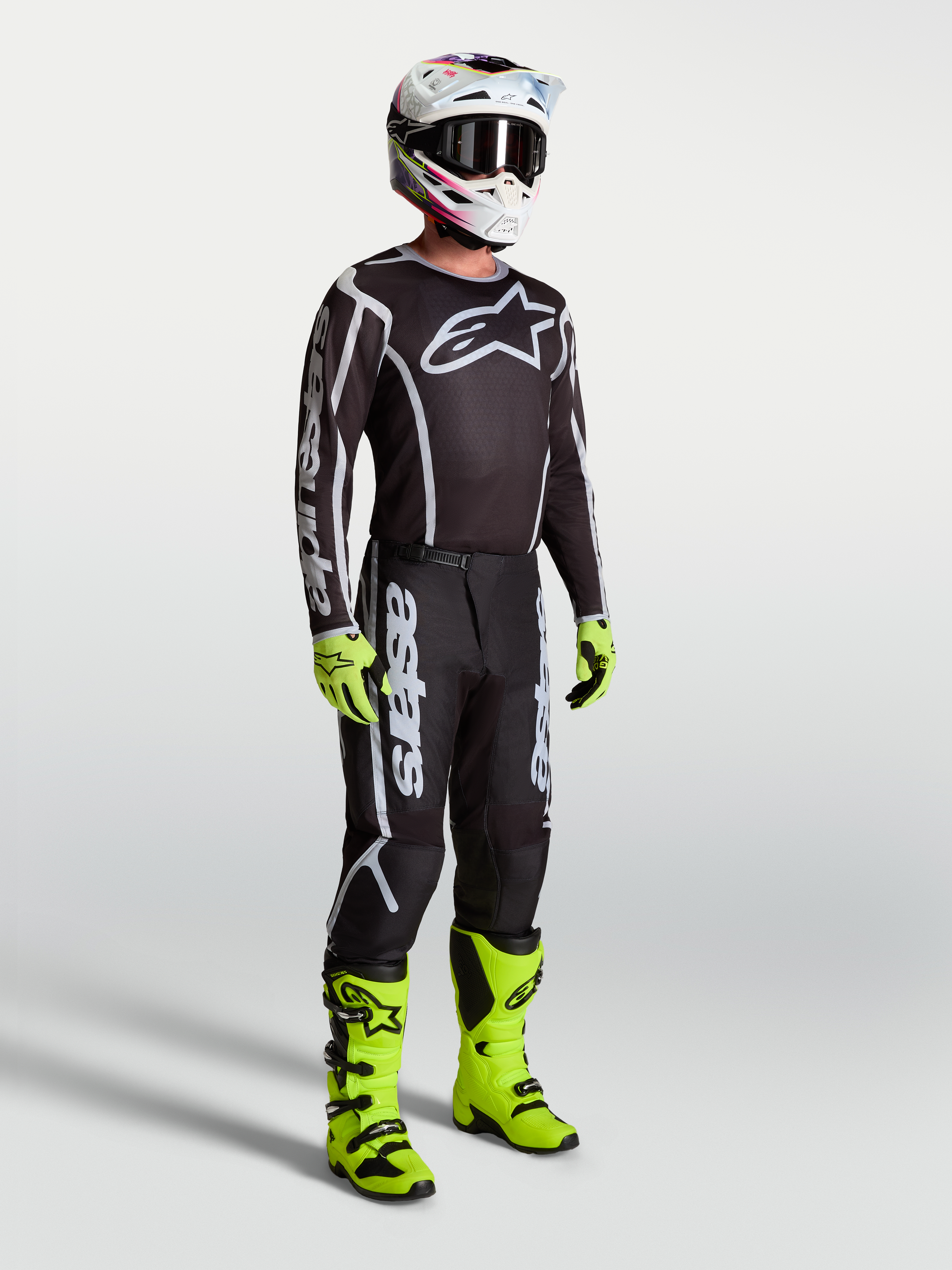 Alpinestars Fluid Apex V2 broek, motorcrossbroek voor heren, zwart en zilver, gedragen door een model in een off-road outfit.