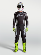 Alpinestars Fluid Apex V2 Pants in Black and Silver, part of a full Men's Motocross gear set with neon yellow boots, helmet, and performance racing jersey.