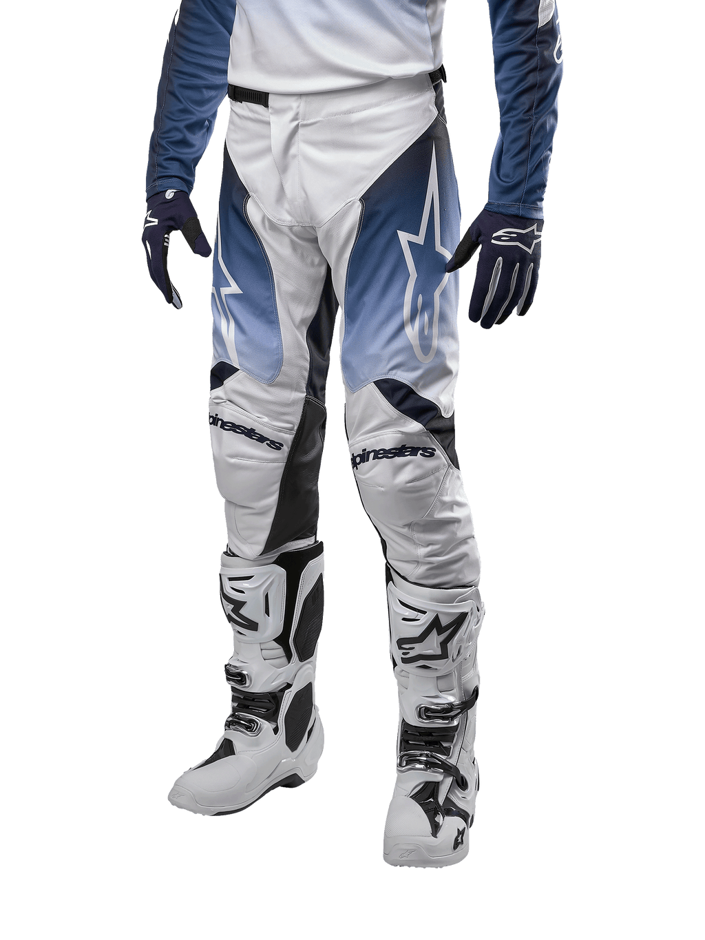 Alpinestars 2024 Racer Hoen Pants, pantalon de motocross, blanc, bleu marine et bleu clair avec logos blancs, équipement de protection haute performance pour tout-terrain, porté avec gants et bottes de motocross.