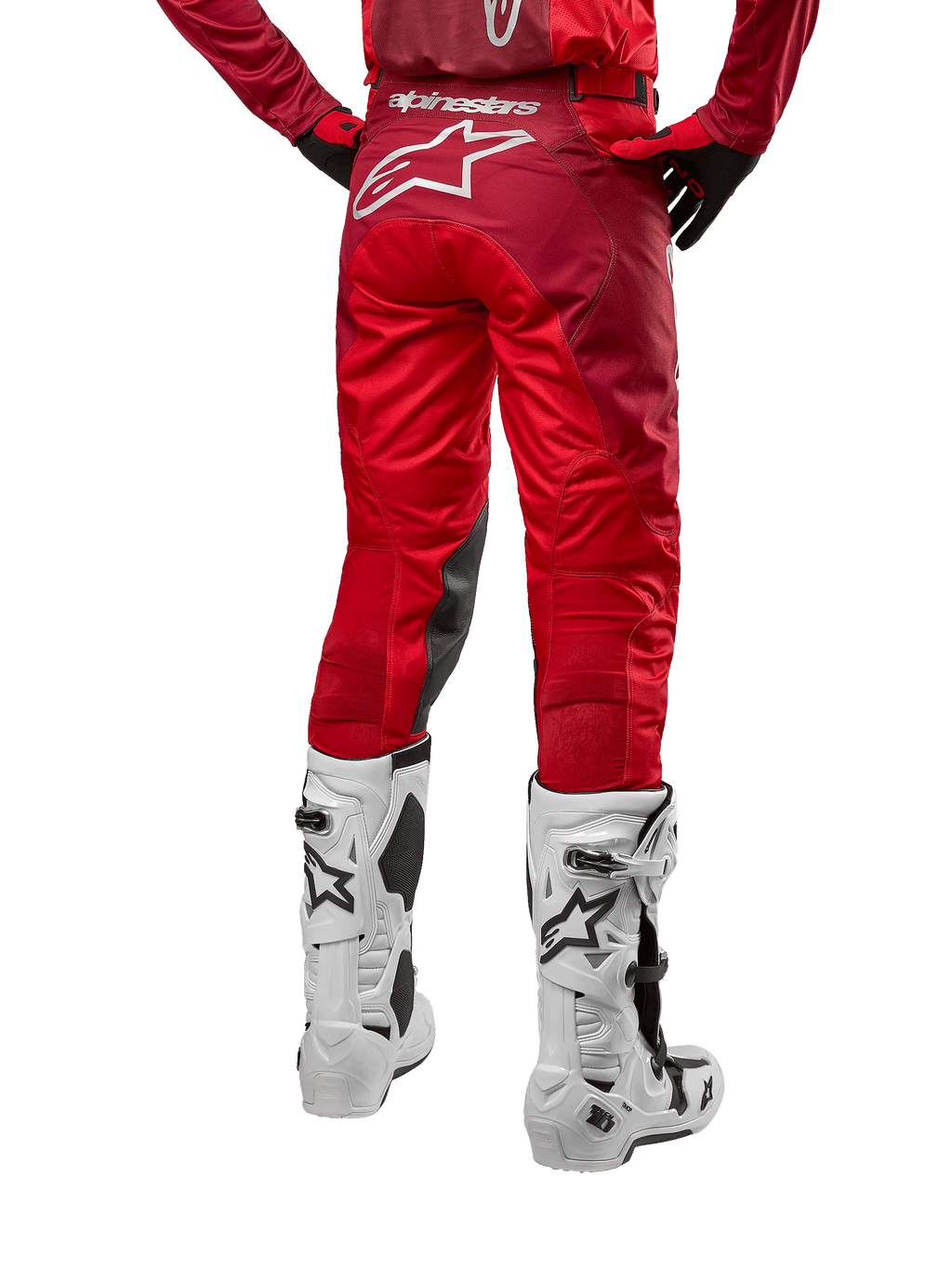 Alpinestars 2024 Racer Hoen Pants, pantalon de motocross, Mars Red Burgundy, vue arrière montrant un grand logo Astar blanc à l'arrière, panneaux intérieurs aux genoux noirs, porté avec des bottes de motocross blanches, équipement tout-terrain haute performance