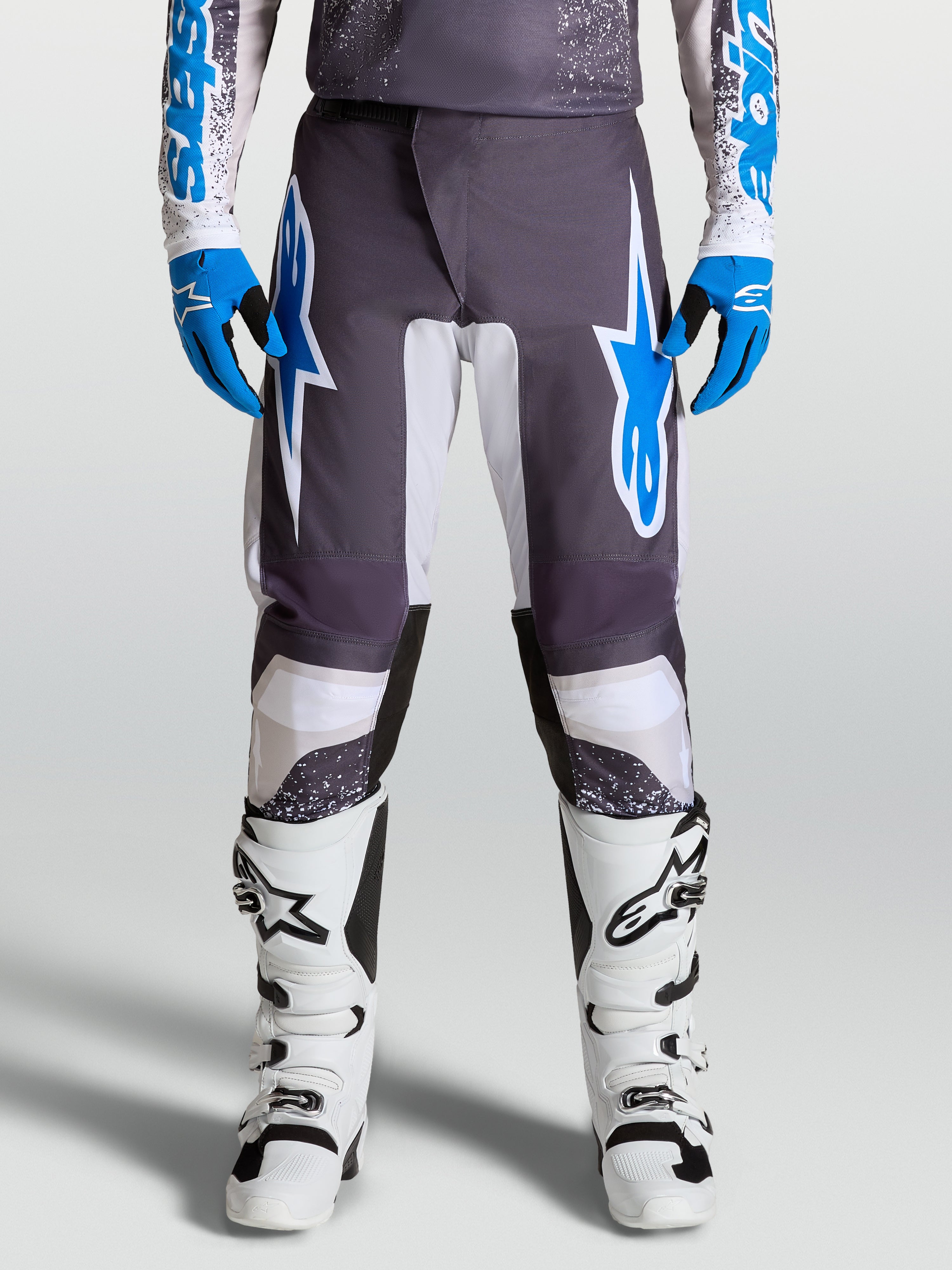 Alpinestars Fluid Drag Hosen für Motocross, Grau und Blau, vorgekrümmte Beine und ergonomischer Schutz aus Poly-Gewebe.