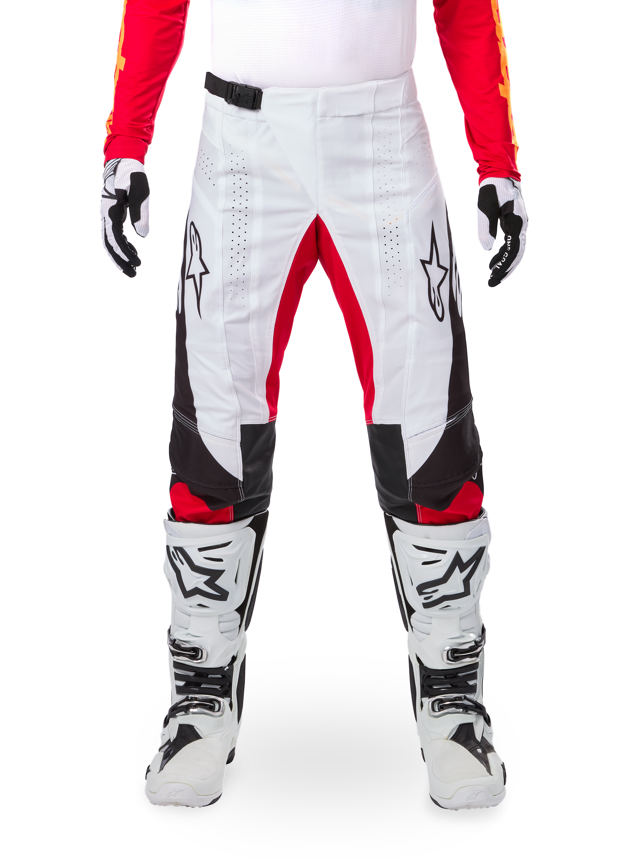 Alpinestars Limited Edition Techstar Deep crossbroek, motorcrossbroek, zwart, wit en felrood, gedragen met bijpassende rode jersey, witte en zwarte handschoenen en laarzen, voorzien van witte voorpanelen, rode accenten aan de binnenkant van de benen, zwarte zijpanelen, Alpinestars-logo's op de dijen en laser-geperforeerde details voor ventilatie.
