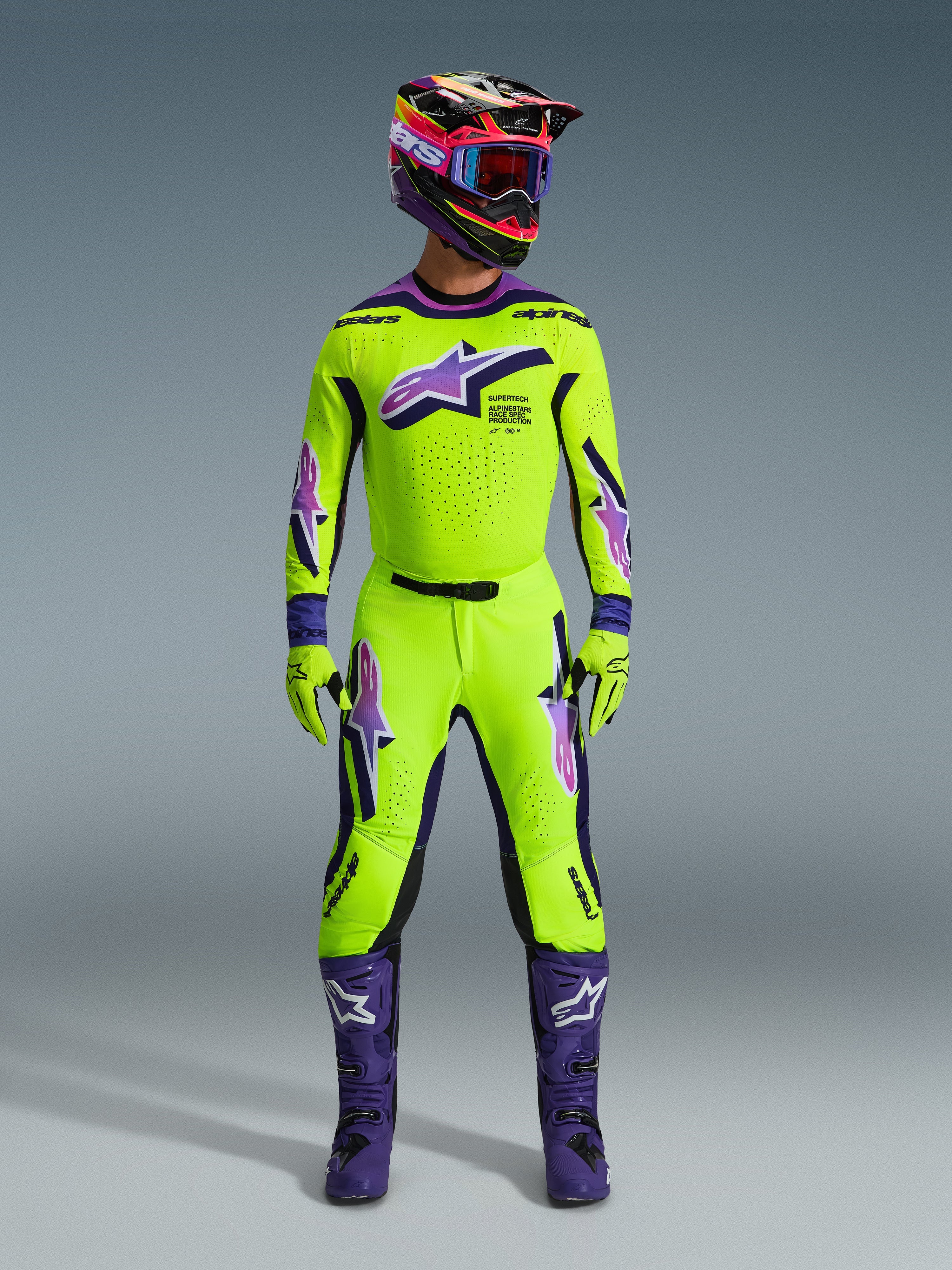 Alpinestars 2026 Supertech Vista Gear Set, tenue de motocross, jaune fluo et violet, comprenant un casque multicolore assorti, un maillot et un pantalon jaune fluo avec des logos violets et blancs, des bottes violettes et des gants coordonnés pour la course tout-terrain