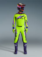 Alpinestars 2026 Supertech Vista Pants, Motocross Pants, Neon Yellow with Purple and Black accents, worn as part of a coordinated racing gear set with matching jersey, helmet, and purple boots, featuring a professional athletic fit and bold logos for off-road performance