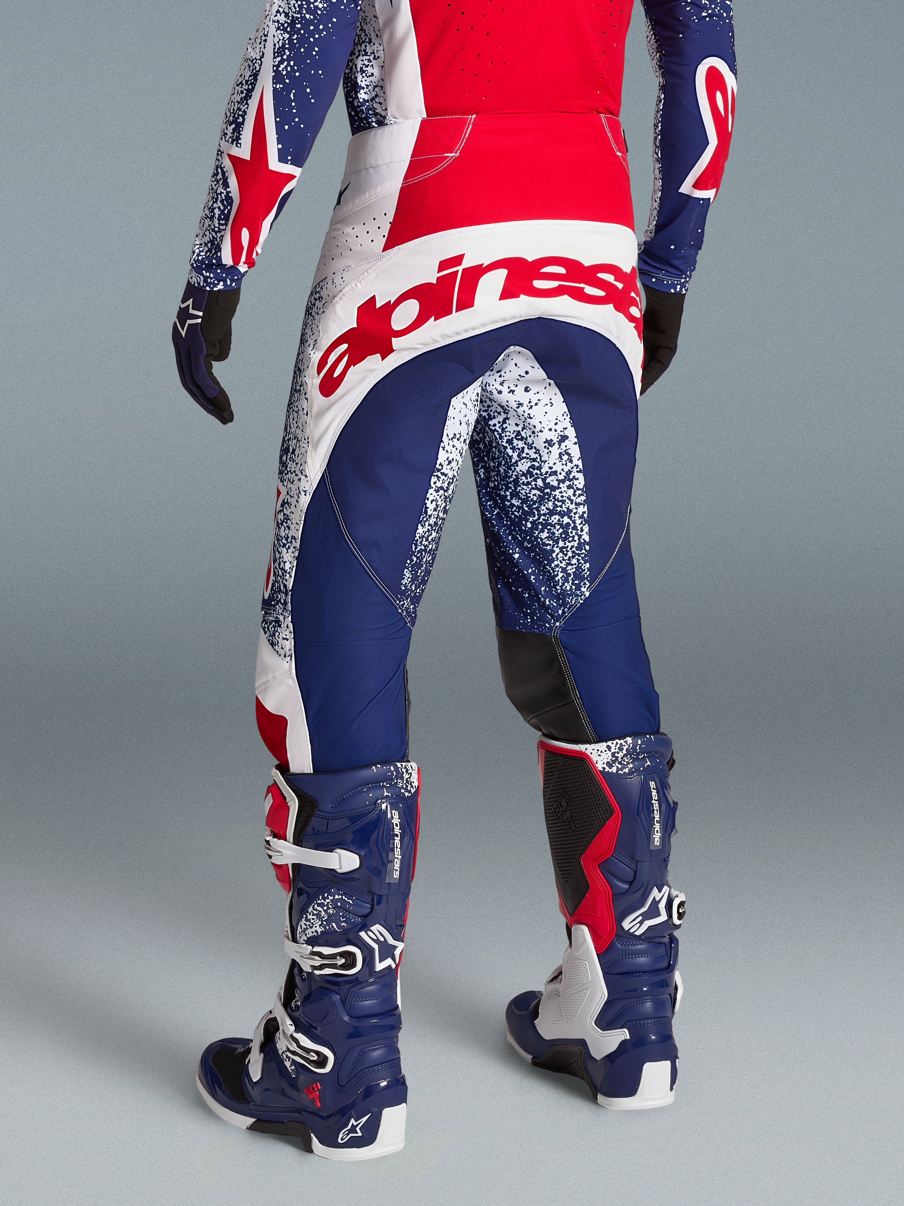 Alpinestars Techstar Unity beperkte oplage kledingset, rood-blauw motocross-pak met opvallende branding achterop.