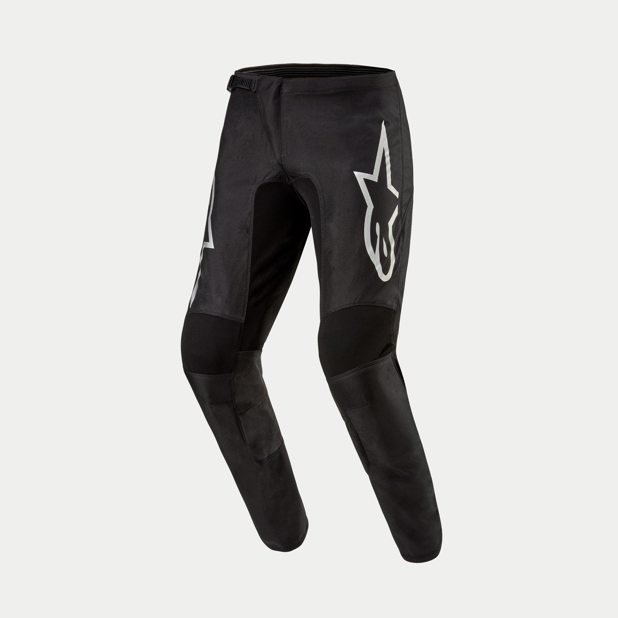 Pantalon Alpinestars Fluid Graphite 2024, pantalon de motocross, noir et argent, avec un grand logo Astar argenté sur la cuisse, panneaux de genoux renforcés noirs et design ergonomique pré-courbé pour la course tout-terrain