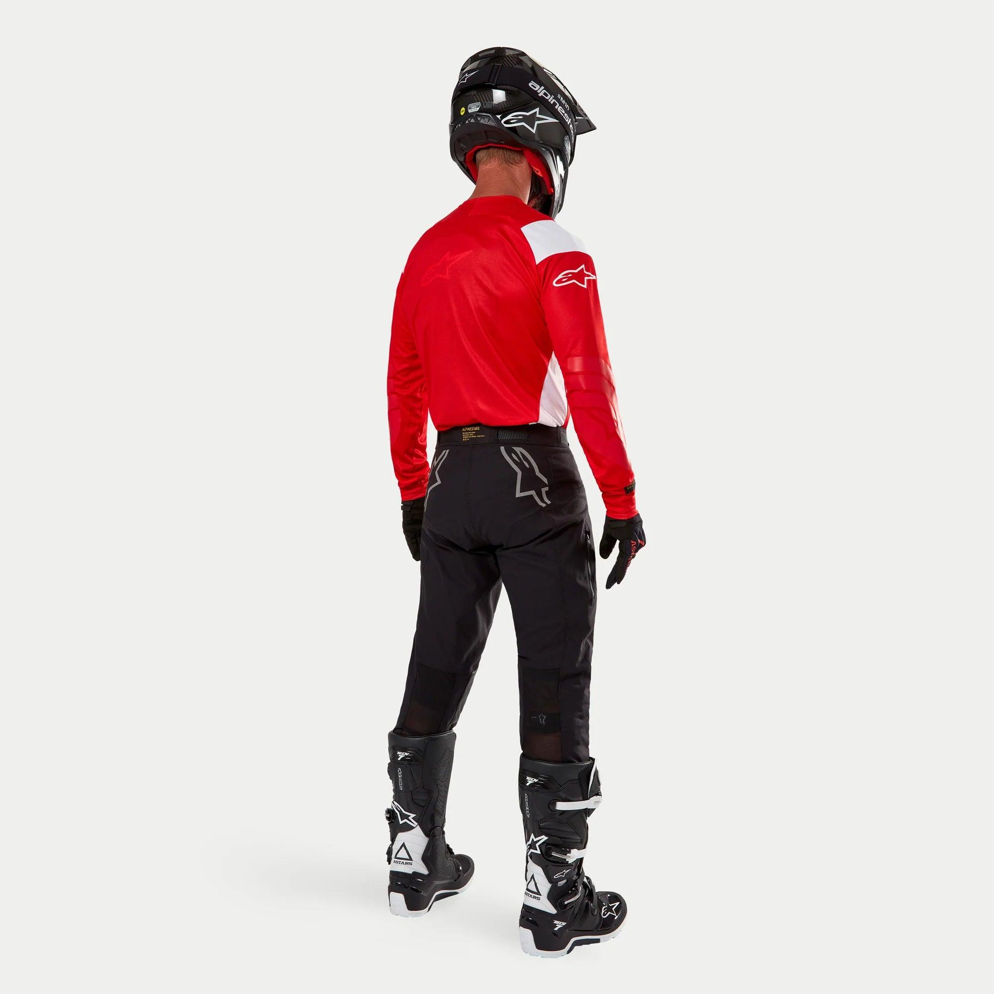 Alpinestars Techdura Pants, Enduro Off-Road Pants, Black, rear view worn by a rider with a red and white jersey and black and white boots, featuring white star logos on the back and durable technical stretch construction.