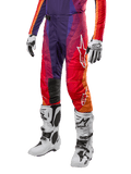 Alpinestars 2024 Techstar Pneuma Hose, Motocross-Hose, Lila, Orange und Blau mit roten Akzenten, Alpinestars-Logo, weiße Motocross-Stiefel und Handschuhe, sportliches Design für den Offroad-Rennsport