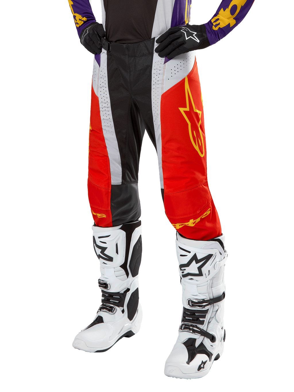 Alpinestars 2024 Techstar Ocuri crossbroek, motorcross racingbroek, feloranje, zwart en wit met geel sterrendesign, gedragen met paarse jersey en witte laarzen, duurzame performance kleding voor off-road competitie