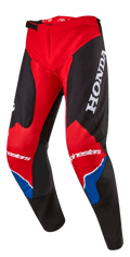 Alpinestars Honda Racer Iconic crossbroek, motorcrossbroek, felrood, zwart en wit met blauwe accenten, voorzien van een groot wit HONDA-logo op de dij, Alpinestars-branding op de knieën, ergonomische voorgevormde beenconstructie en verstelbare ratelsluiting in de taille.
