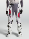 Alpinestars Jeugd Supertech Swan broek 2027, grijze en lila motocross-racebroek met rode accenten en witte motorlaarzen.