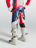 Alpinestars Youth Supertech Dyna Pants, fire red and navy blue motocross trousers for young riders, shown from the rear.