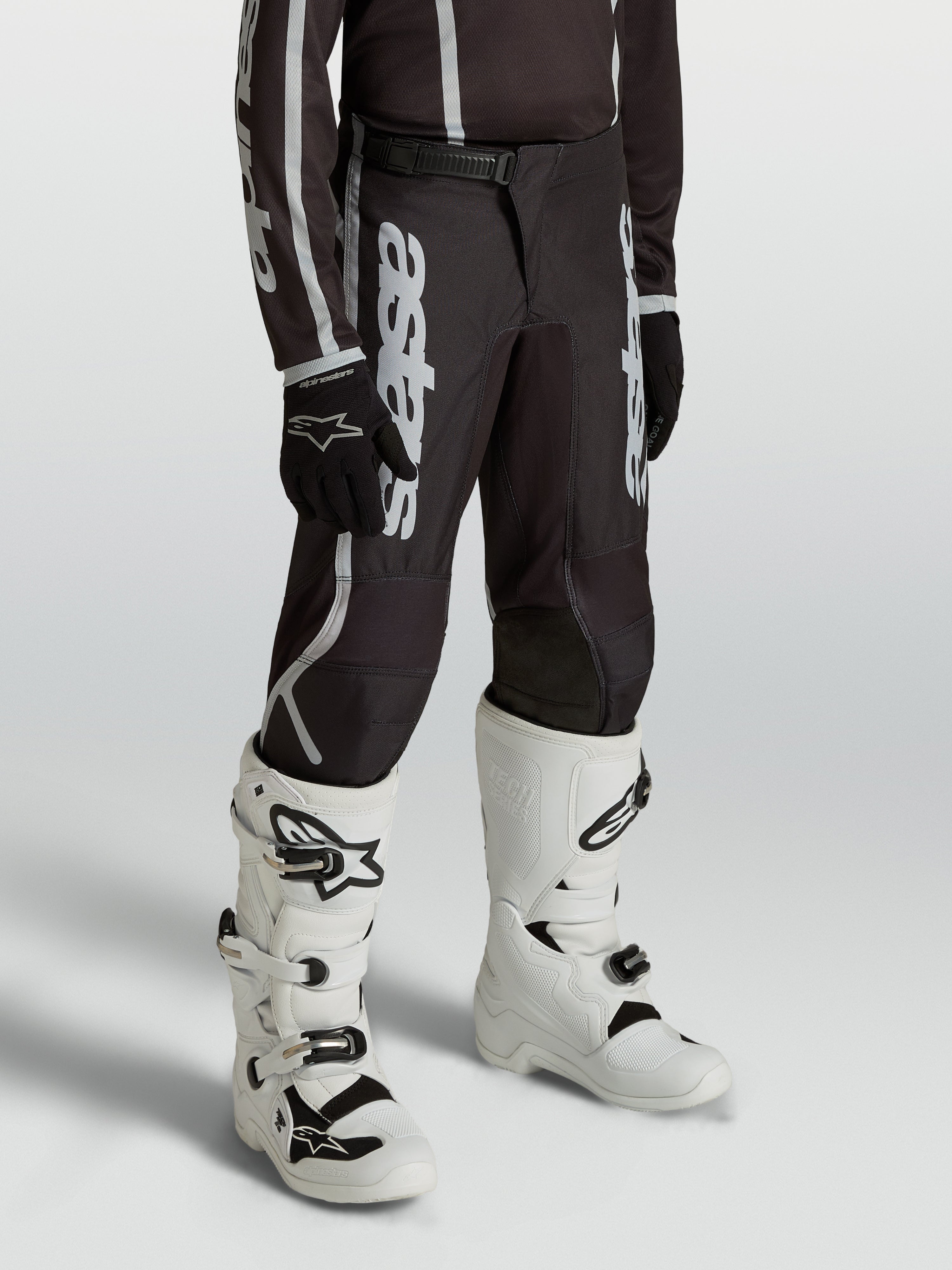 Alpinestars Jeugd Fluid Apex V2 broek, motocrossbroek voor kinderen, zwart en zilver, ergonomische voorgebogen pasvorm.