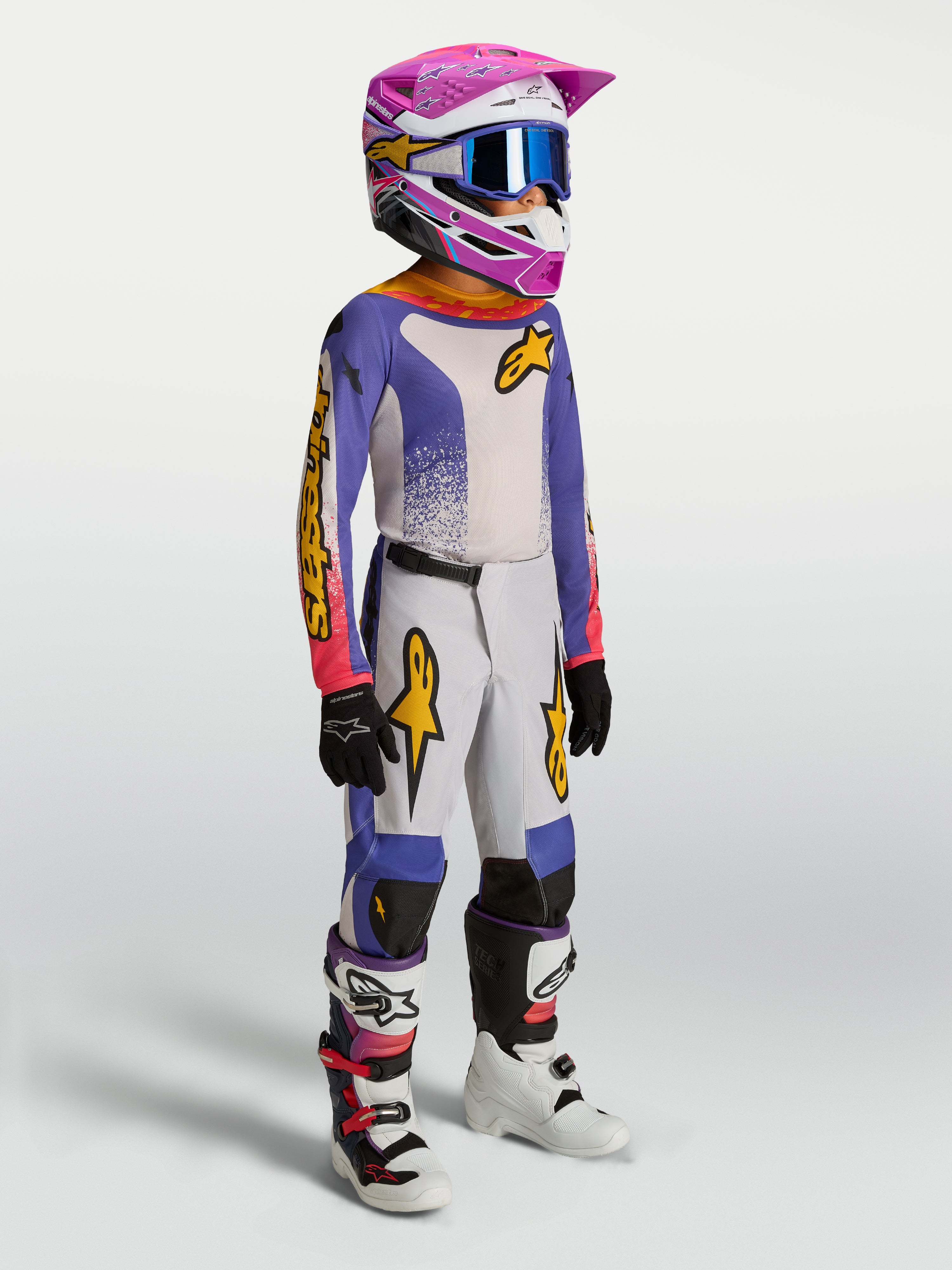 Alpinestars Jeugd Fluid Drag broek, blauwe en gouden motocrossbroek voor jeugd, ergonomische pasvorm, gedragen door model.