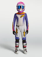 Alpinestars Jeugd Fluid Drag broek, paarse en witte motorcrossuitrusting voor off-road rijden met gouden accenten.