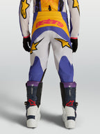 Alpinestars Jeugd Fluid Drag broek 2027, blauwe en gouden motorcrossbroek met ster-graphics, achteraanzicht, 600D constructie