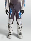 Alpinestars pantalon Fluid Drag Junior, équipement de motocross pour enfant, sable et bleu, polyfibre 600D avec renforts aux genoux, porté avec des bottes blanches