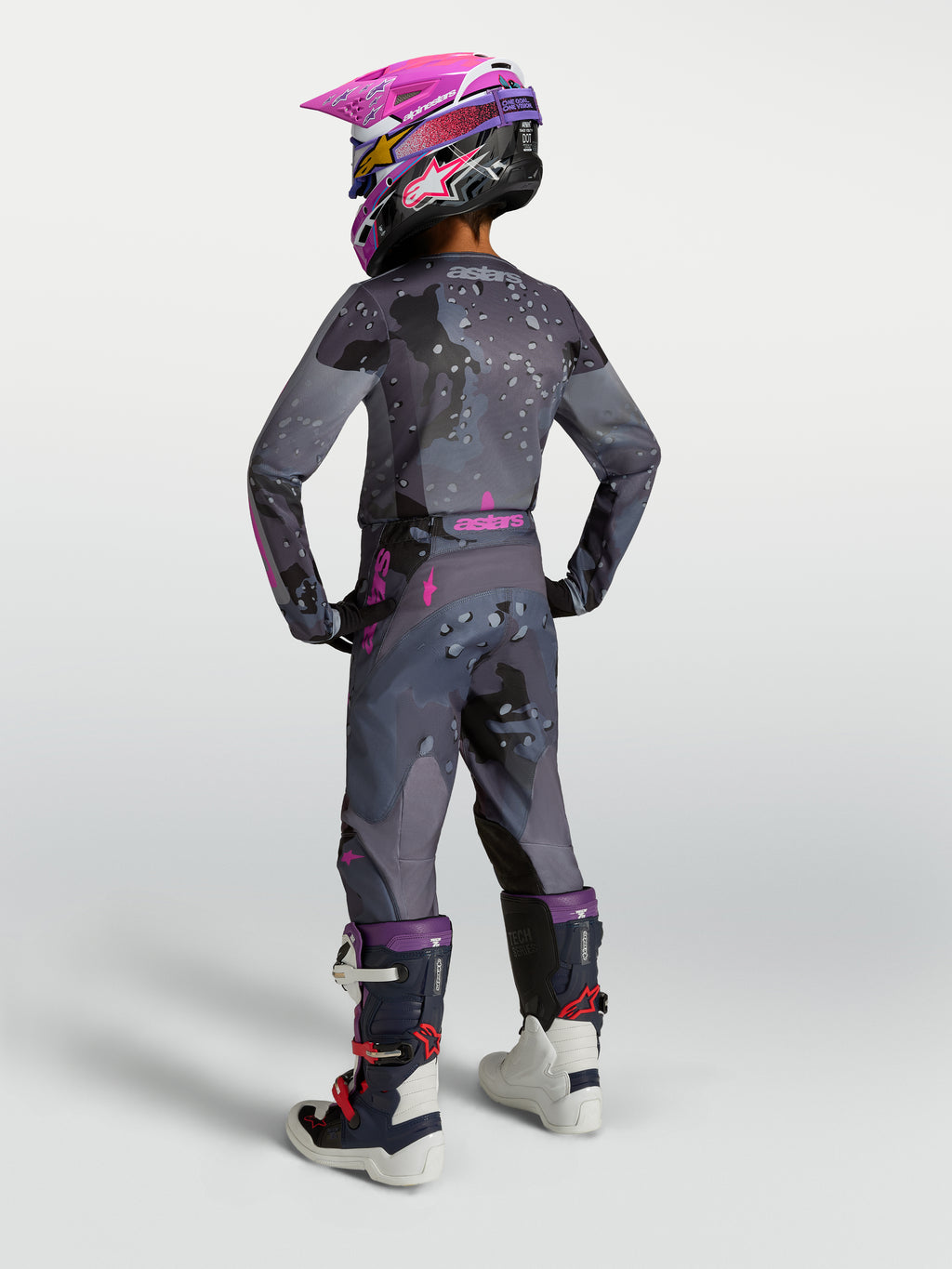Ensemble Alpinestars Junior Fluid Lone, équipement de motocross gris et rose, vue de dos avec casque et bottes assortis