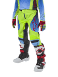 Alpinestars Youth 2024 Racer Hoen Pants, Motocross Pants, Yellow Fluo and Blue Night Navy with red accents, worn with matching gloves and white, black, and red boots, featuring a sport fit and pre-curved legs for off-road racing