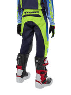 Alpinestars Youth 2024 Racer Hoen Pants, Motocross Pants, Yellow Fluo and Blue Night Navy, rear view showing bold Alpinestars branding on the waistband, worn with black and red Tech Series boots and coordinating jersey, durable sport fit for youth off-road riding