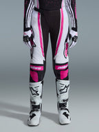 Alpinestars 2026 Woman Stella Techstar Nomur Pants, Motocross Pants, Black White and Fuchsia, worn with matching racing jersey, gloves, and white motocross boots, featuring bold pink graphics and astars logos on the knees, designed for high-level off-road competition.
