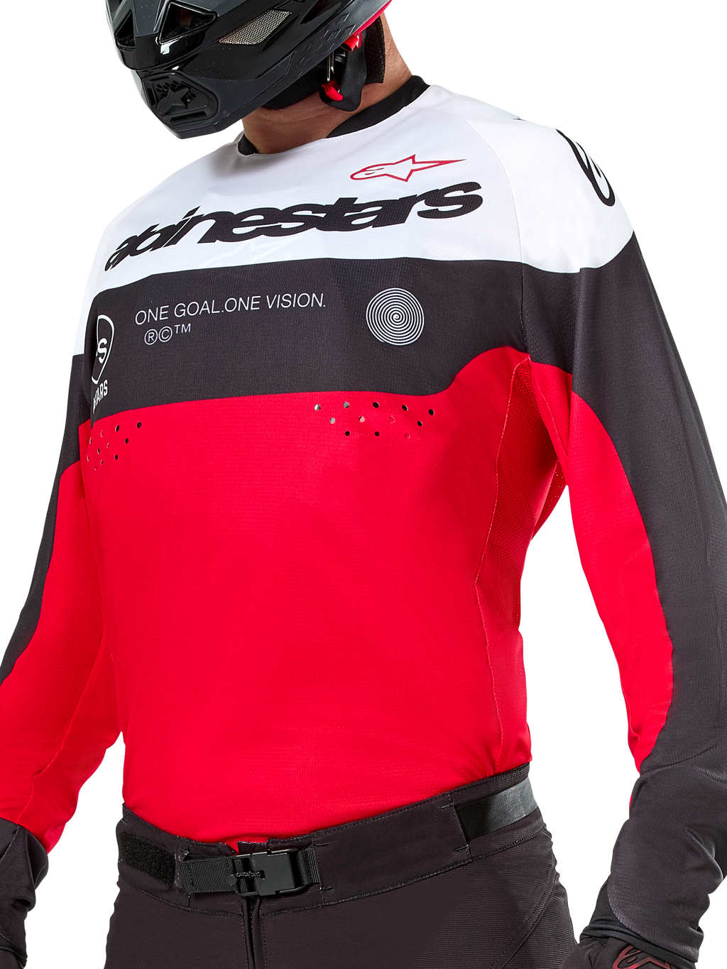 Maillot Alpinestars Pro-Dura, maillot de motocross et d'enduro, noir, rouge vif et blanc, avec le graphisme « ONE GOAL. ONE VISION. » et des perforations laser sur la poitrine, porté avec un pantalon de motocross et un casque noirs.