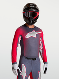 Alpinestars Supertech Hiten AFD jersey, ademende heren motocross-top in grijs en fluo rood, gedragen door een motorcrosser.