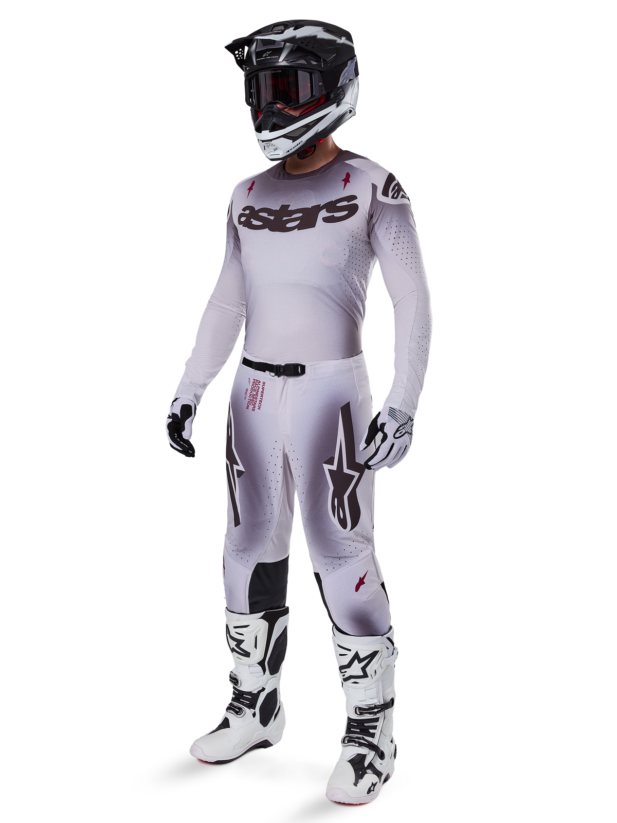 Alpinestars 2025 Supertech Maker Gear Set, complete motorcross outfit, wit en grijs kleurverloop met zwarte branding en rode accenten, inclusief helm met crossbril, jersey, broek, witte laarzen en handschoenen, strak prestatiegericht ontwerp voor off-road racen
