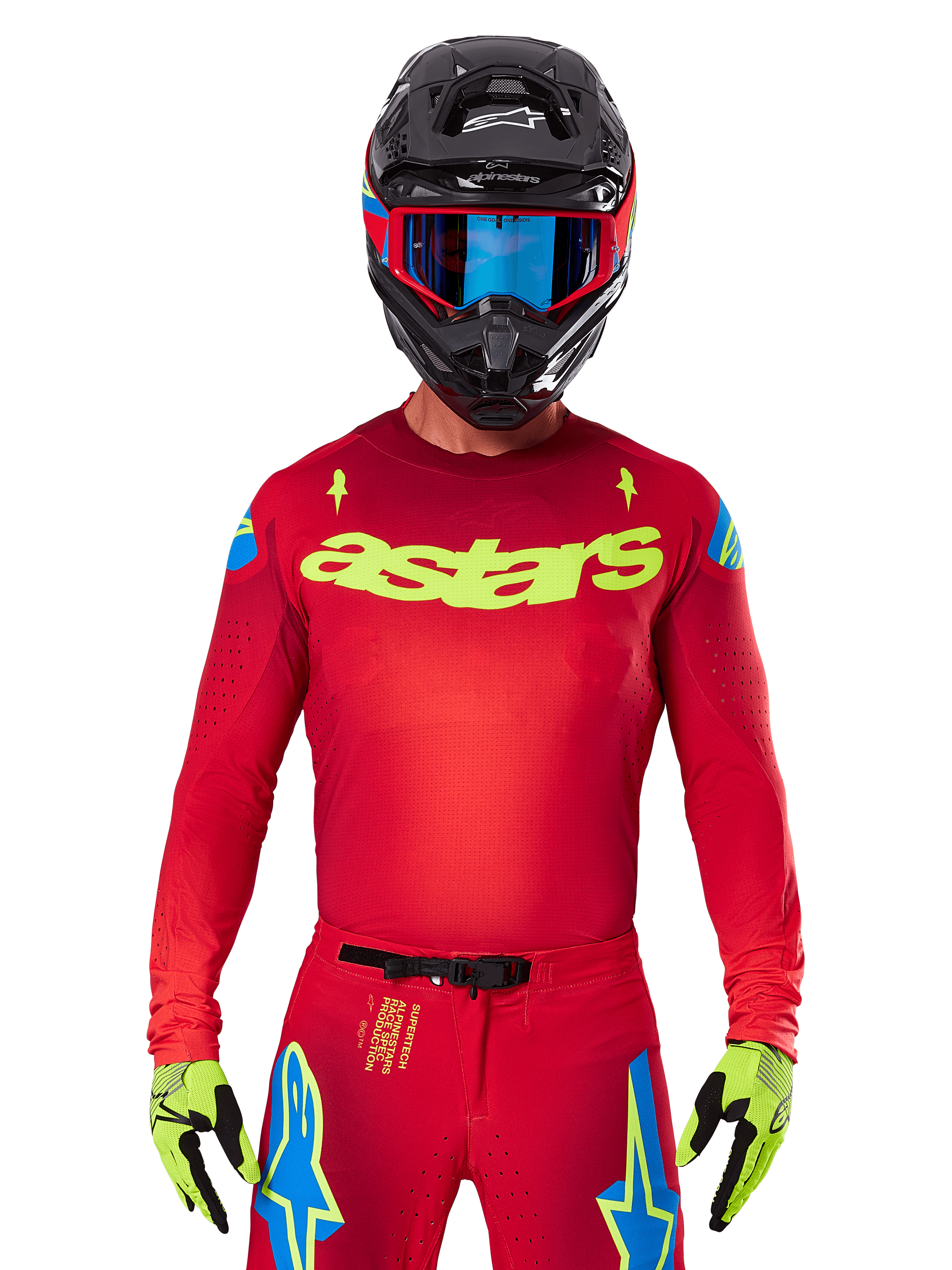 Alpinestars 2025 Supertech Maker Jersey in Bright Red Yellow Fluo, met geel 'astars' logo op de borst en blauwe sterrendesigns op de schouders, gedragen met bijpassende broek, zwarte helm, blauwe bril en gele handschoenen, professionele motorcross racekleding