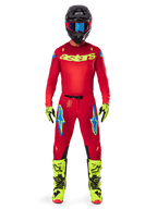 Motocross-Fahrer im Alpinestars 2025 Supertech Maker Jersey und passender Hose in Bright Red und Yellow Fluo, gelbes „astars“-Branding auf der Brust, schwarzer Helm mit blauer Brille, Yellow-Fluo Handschuhe und Stiefel, komplettes professionelles Rennoutfit für Offroad-Performance.
