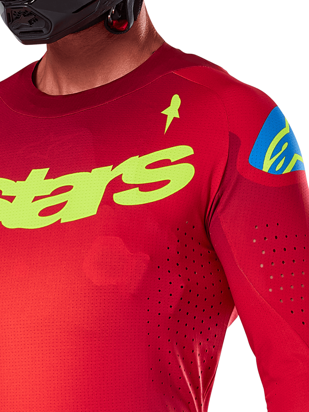 Alpinestars 2025 Supertech Maker Trikot, Motocross-Trikot, Hellrot und Fluogelb, Nahaufnahme mit lasergeschnittenen Perforationen, gelber Alpinestars-Schriftzug auf der Brust, blaues Schulterdetail, atmungsaktives Stretch-Mesh-Gewebe