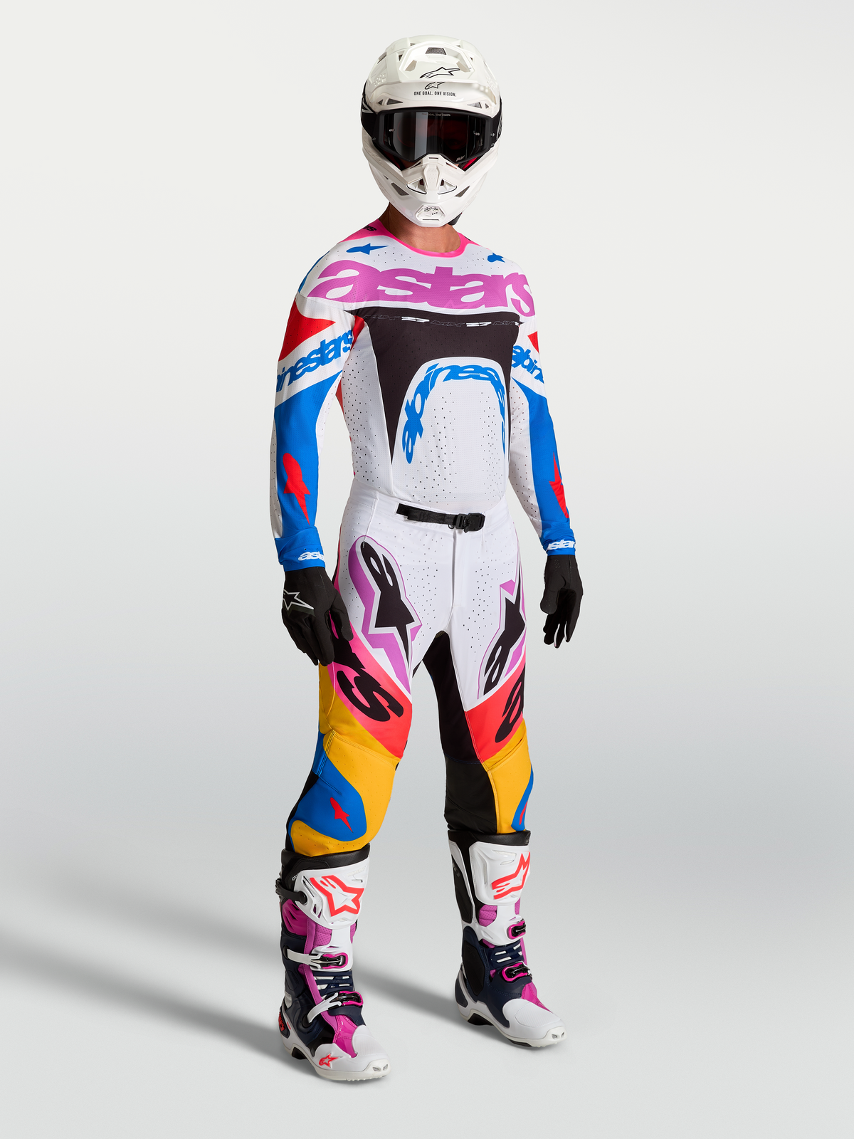 Alpinestars Supertech Dyna Ausrüstungsset, weiß-blaues Herren-Motocross-Rennoutfit mit pinken Akzenten am Model.