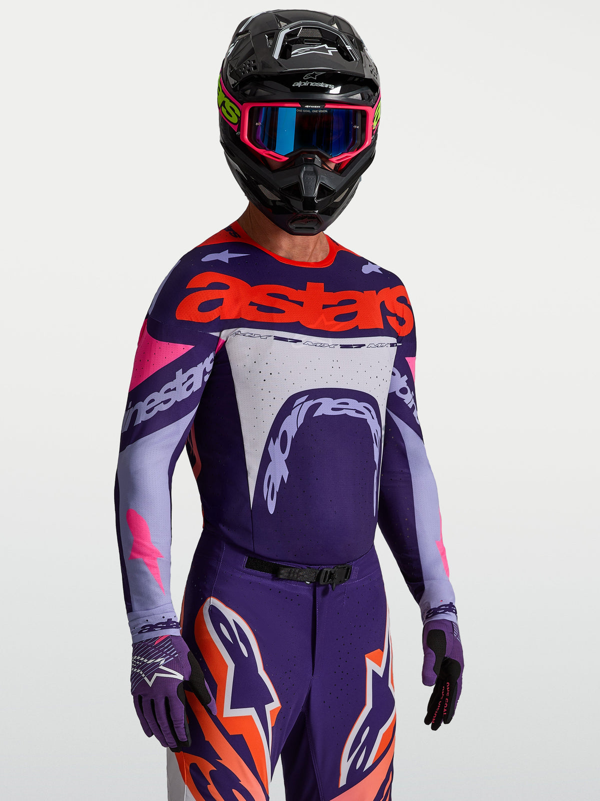Alpinestars Supertech Dyna Trikot, Motocross-Oberteil für Herren, Lila und Pink Fluo, aus leichtem Stretch-Mesh mit Laserperforationen, getragen von einem Fahrer mit Helm und Handschuhen, professionelle MX-Rennausrüstung