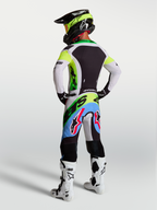 Alpinestars Supertech Dyna jersey en gear set, heren-motorcrosskleding in groen fluo en lila, achteraanzicht van complete professionele race-uitrusting.