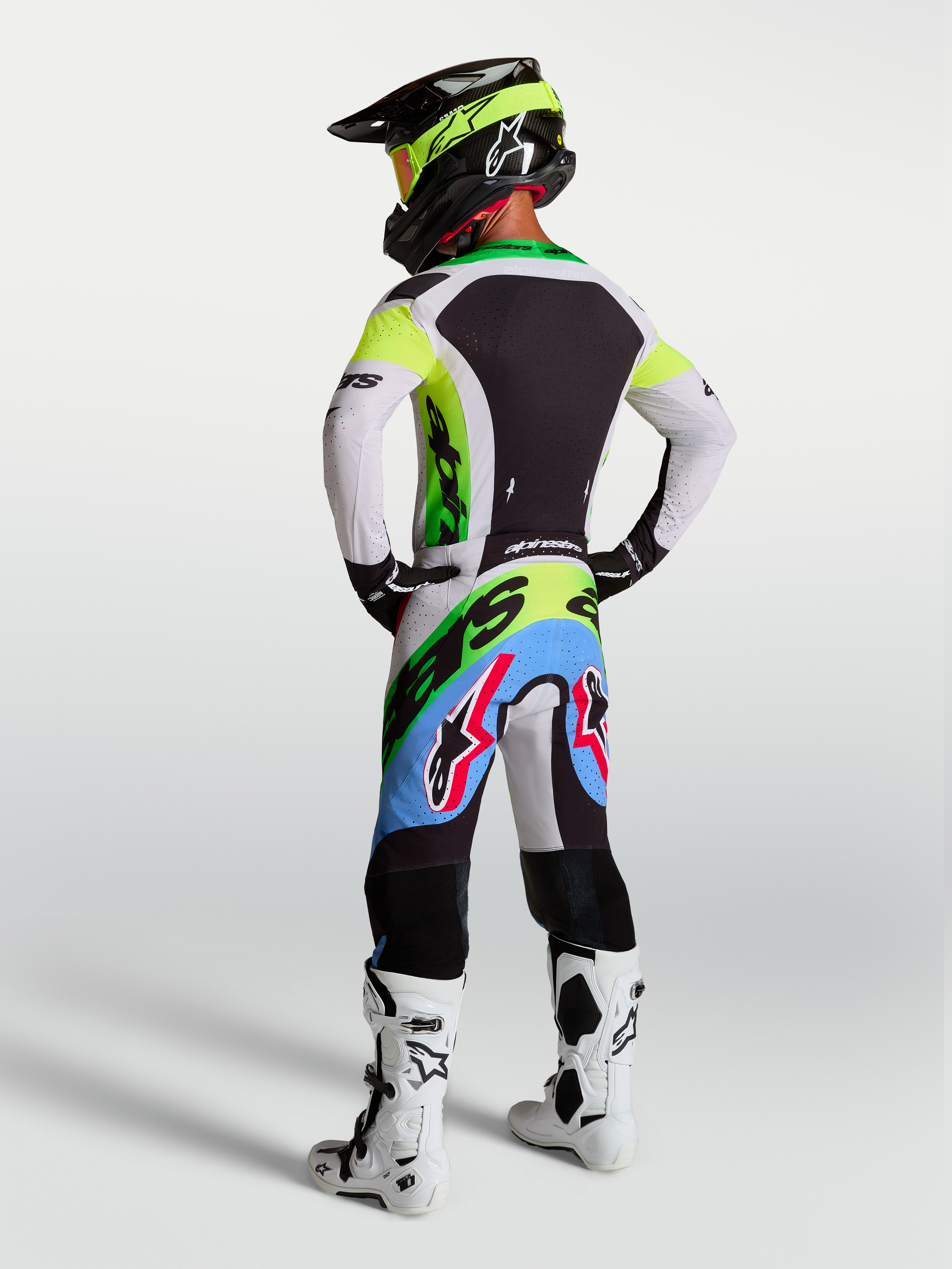 Alpinestars Supertech Dyna jersey en gear set, heren-motorcrosskleding in groen fluo en lila, achteraanzicht van complete professionele race-uitrusting.