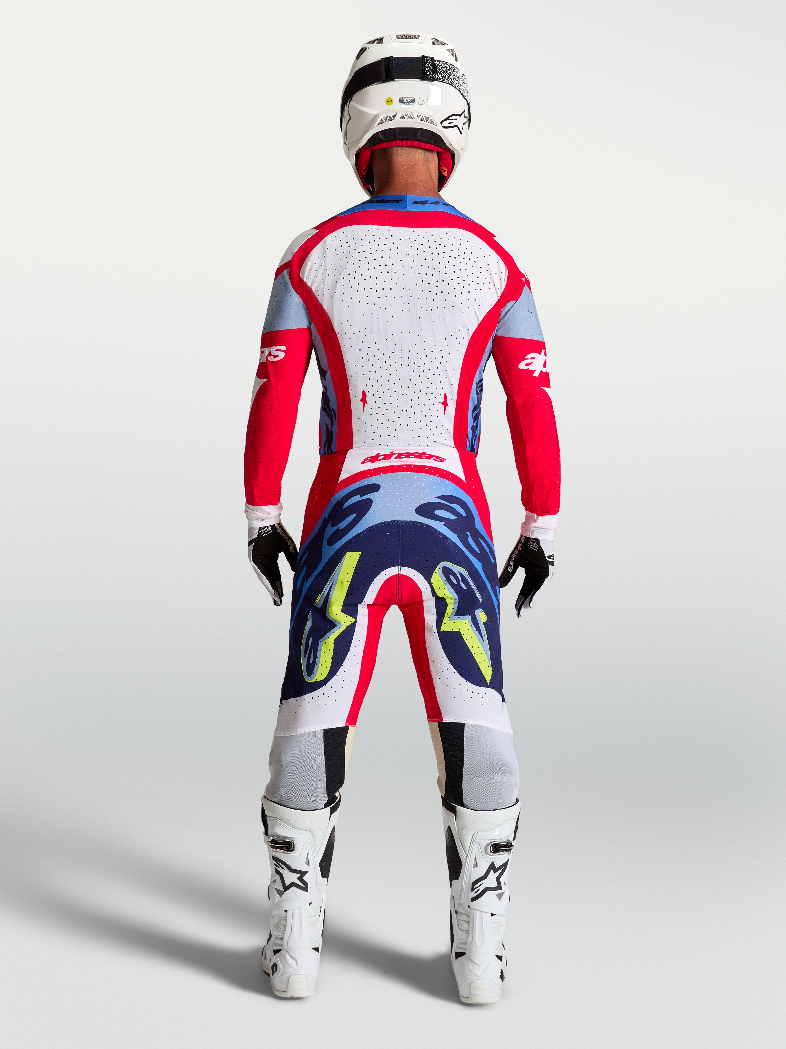 Alpinestars Supertech Dyna jersey en 2027 Supertech Dyna gearset, heren-motorcrossoutfit in rood en wit, achteraanzicht.